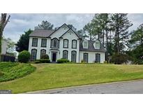 Classic two-story home boasting a well-manicured lawn and charming architectural details at 303 Sedgewick Trl, Lawrenceville, GA 30044