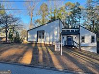 Modern home features a unique architectural design, blue front door, and manicured lawn at 783 Lost Creek Cir, Stone Mountain, GA 30088