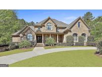 Charming brick home with a lush green lawn and beautifully landscaped front yard at 310 Westbourne Dr, Tyrone, GA 30290