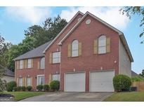 Charming two-story brick home featuring a two-car garage and well-maintained landscaping at 6697 Princeton Park Walk, Lithonia, GA 30058