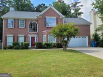 Charming two-story brick home with well-manicured lawn and a two car attached garage at 5070 Saddle Bridge Ln, Alpharetta, GA 30022