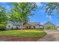 Charming single-story home with a beautiful lawn, porte-cochere, and inviting curb appeal at 877 Honey Creek Rd, Mcdonough, GA 30252