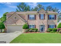 Charming brick two-story home with a well-manicured lawn and meticulously maintained landscaping at 340 Aster Ridge Trl, Peachtree City, GA 30269