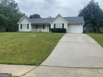 Charming single-story home with green lawn, driveway and attached garage at 248 Fern Ct, Hampton, GA 30228