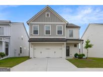 Charming two-story home featuring a two-car garage, manicured lawn, and inviting curb appeal at 4003 Garden Ln, College Park, GA 30337