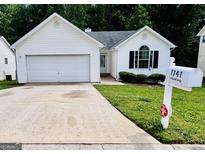 Charming one-story home with a well-maintained front yard and an attached garage at 1741 Portwest Way, Hampton, GA 30228