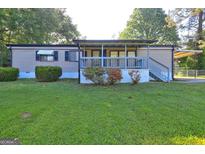 Charming home with a cozy front porch and well-maintained lawn at 50 Caroline Ave, Stockbridge, GA 30281