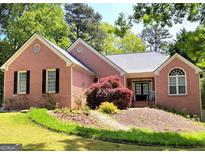 Charming brick home with well-manicured lawn and beautiful landscaping, creating inviting curb appeal at 1510 Heritage Dr, Cumming, GA 30041