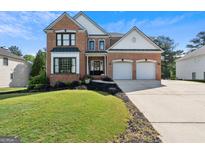 Charming two-story brick home featuring a well-manicured lawn, two-car garage, and lovely curb appeal at 3006 Gold Creek Dr, Villa Rica, GA 30180