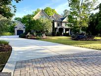 Beautiful two-story brick home with attached garage, large driveway, and manicured landscaping at 1345 Cashiers Way, Roswell, GA 30075