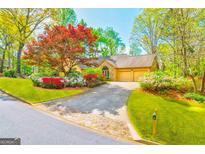 Charming home with lush landscaping, colorful flowers, and a welcoming stone-accented facade at 8575 Haven Wood Trl, Roswell, GA 30076