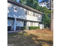 Two-story townhouse featuring a well-maintained front yard with a trimmed hedge and mature trees at 3818 Mulkey Sw Cir, Marietta, GA 30008