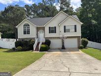 Charming two-story home with attached two-car garage, landscaped yard, and traditional architectural details at 85 Creekside Trl, Covington, GA 30016