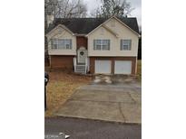 Charming split-level home with a two-car garage, brick accents, and welcoming front entrance at 213 Bonnie Sue Dr, Villa Rica, GA 30180
