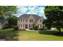 Traditional brick home with manicured lawn and landscape, complemented by dark shutters and detailed entrance at 1120 Twin Bridge Ln, Peachtree City, GA 30269
