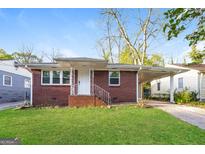 Charming brick home featuring a well-maintained lawn and covered parking at 338 Mount Zion Rd, Hapeville, GA 30354