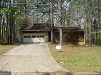 Charming single-Gathering home with a two-car garage surrounded by mature trees and an extended driveway at 3208 Berrong Way, Stone Mountain, GA 30087