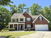 Charming two-story home with a brick facade, attached garage, manicured lawn and mature landscaping at 345 Manning Ct, South Fulton, GA 30349