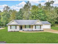 Charming single-story home featuring a well-manicured lawn, neutral siding, and a two-car garage at 221 Courthouse Park Dr, Temple, GA 30179