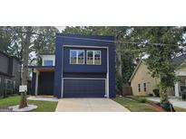 Striking modern home features a beautiful blue exterior, a garage, and lovely green lawn at 1378 Gus Thornhill Jr Dr, East Point, GA 30344