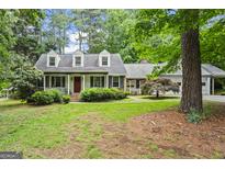 Charming home with a well-manicured lawn, inviting front porch, and mature trees at 1680 Huntington Dr, Marietta, GA 30066