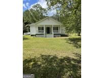 Charming single-story home with a spacious front yard, inviting porch, and classic architectural details at 871 Clearwater Rd, Sharpsburg, GA 30277
