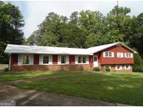Charming home featuring a well-manicured lawn and timeless architectural details at 5875 Highway 92, Fairburn, GA 30213