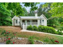 Charming home featuring a covered front porch, bay windows and lush landscaping at 142 Pebblebrook Way, Temple, GA 30179