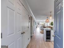 Inviting entryway with wood floors flowing into a bright, open living space with modern kitchen and a glimpse of the backyard at 705 Berry Ct, Villa Rica, GA 30180
