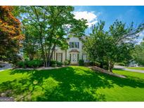 Charming two-story home featuring a well-manicured lawn and mature trees with a bay window at 1130 S Rudder Rd, Cumming, GA 30041