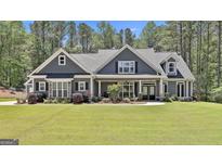Charming gray home featuring a well-manicured lawn and complementing exterior landscaping at 120 Laurel Forest Dr, Tyrone, GA 30290