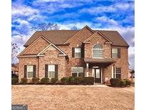 Two-story brick home with a well-manicured lawn and inviting front porch at 162 Aylesbury Blvd, Mcdonough, GA 30252