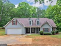Charming single-story home features gray siding, brown roof and attached two-car garage at 445 Royal St, Mcdonough, GA 30253