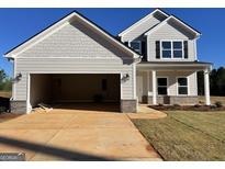 Two-story home with a large garage, gray siding, and a manicured lawn at 715 Colvin Dr, Locust Grove, GA 30248