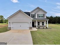 Charming two-story home featuring a two-car garage and beautiful lawn at 715 Colvin Dr, Locust Grove, GA 30248