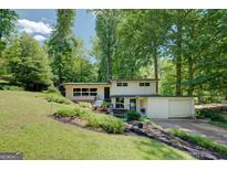 Attractive two-story home with a garage, complemented by lush landscaping and mature trees at 3449 Archwood Dr, Doraville, GA 30340