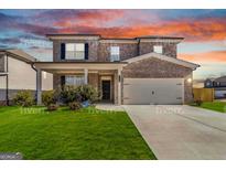 Charming two-story home with brick and stone accents, a well-manicured lawn, and an attached two-car garage at 3460 Sycamore Sw Dr, South Fulton, GA 30331