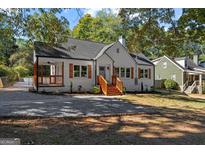 Charming white-brick home featuring wood shutters, a covered porch, and a well-maintained front yard at 985 Columbia Dr, Decatur, GA 30030