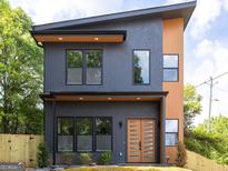 Modern two-story home with a unique design, featuring a gray facade, wood accents, and a stylish front door at 104 Meldon Se Ave, Atlanta, GA 30315