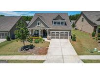 Beautiful one-story home featuring a manicured lawn and a two-car garage at 100 Maple Leaf Rd, Sharpsburg, GA 30277