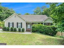 Charming single-story home featuring a cozy front porch and well-maintained landscaping at 1211 Fly Rod Ln, Loganville, GA 30052
