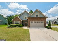 Charming home featuring stone and blue siding, a well-manicured lawn, and an attached two-car garage at 207 Brookstone Dr, Carrollton, GA 30116