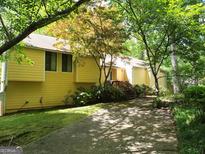 Charming yellow home with wood accents and mature trees in a tranquil setting at 363 Weatherstone Ln, Marietta, GA 30068