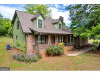 Charming brick home with inviting front porch and lush landscaping at 74 Price W Dr, Locust Grove, GA 30248