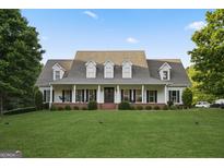 Beautiful exterior showcasing a charming two-story home with well-manicured lawn and inviting front porch at 885 Kelleytown Rd, Mcdonough, GA 30252