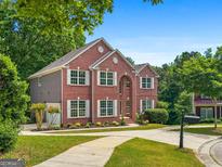 Beautiful two-story brick home with a manicured lawn and a circular driveway at 1429 Kentmire Court, Locust Grove, GA 30248