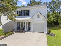 Charming two-story home with a well-manicured lawn and a spacious driveway on a sunny day at 11255 Wittenridge Dr, Alpharetta, GA 30022