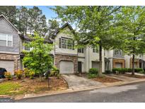 Beautiful townhome features an attached garage, stone accents, and mature trees at 547 Se Tufton Se Trl, Atlanta, GA 30354