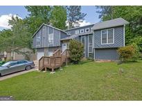 Charming two-story home featuring a blend of siding and stone accents, set amidst a lush green lawn and mature trees at 2673 Deerfield Sw Cir, Marietta, GA 30064