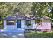 Charming, remodeled single-story home boasts a brick facade, mature trees, and a well-manicured lawn at 2066 Tidwell Trl, Stone Mountain, GA 30088
